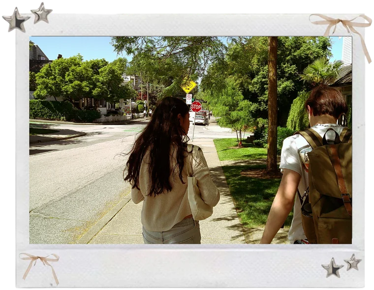 A polaroid with little bows and stars: Pavni and a friend walking down a sunny tree-lined street